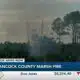 Firefighters work to put out a Hancock County marsh fire
