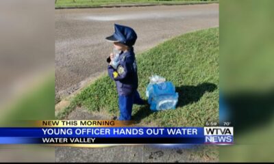 Young officer hands out water to first responders in Water Valley