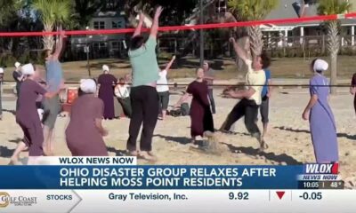 Amish volunteers relax on the beach after helping Moss Point residents