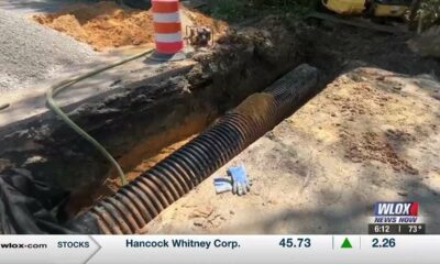 Workers install drainage pipe under Martin Bluff Road to stop flooding delaying widening project