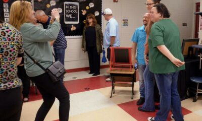 Former students gather for a photo at Coston Elementary during an open house ahead of the school's closure.