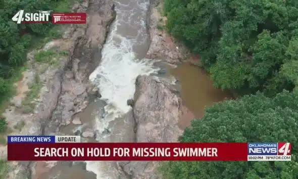 Search on hold for missing swimmer