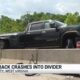 Pickup truck crashes into divider